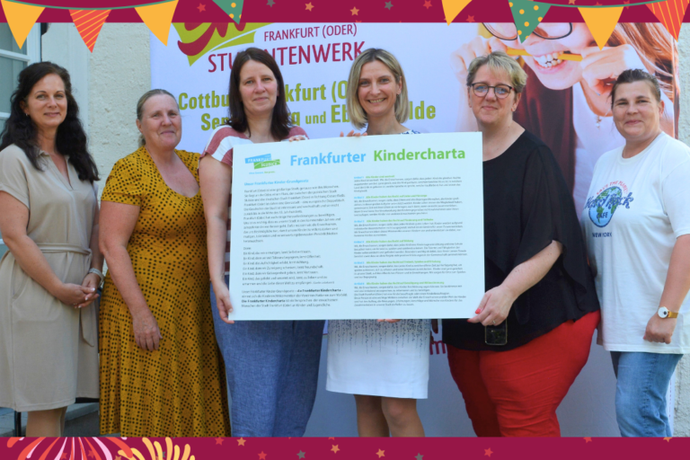 Eine Gruppe von Frauen, die das Schild der Kindercharta halten.